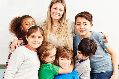 Lächelnde Betreuerin, umringt von einer Gruppe fröhlicher Kinder